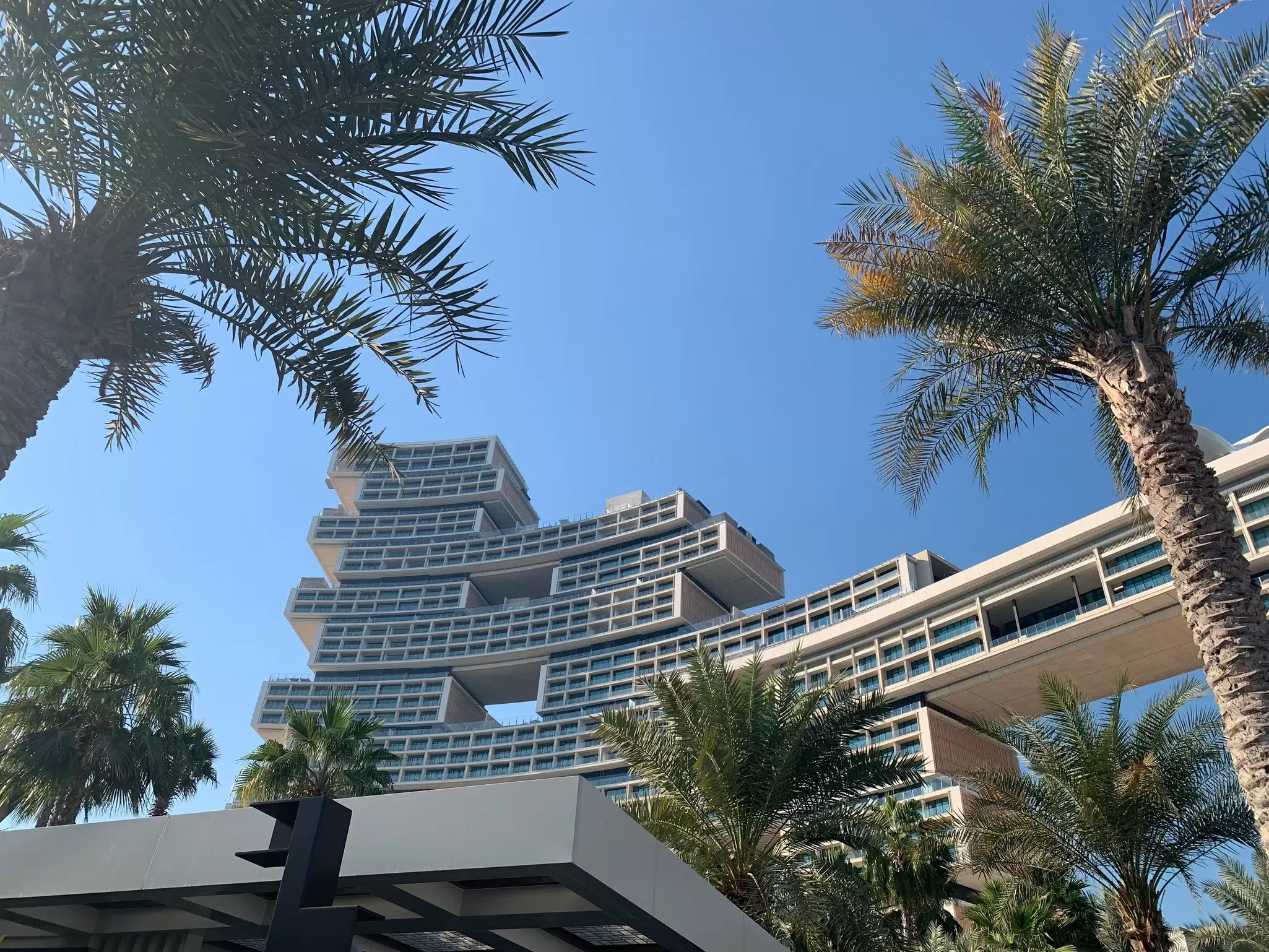 A hotel made up of blocky geometric sections surrounded by palm trees