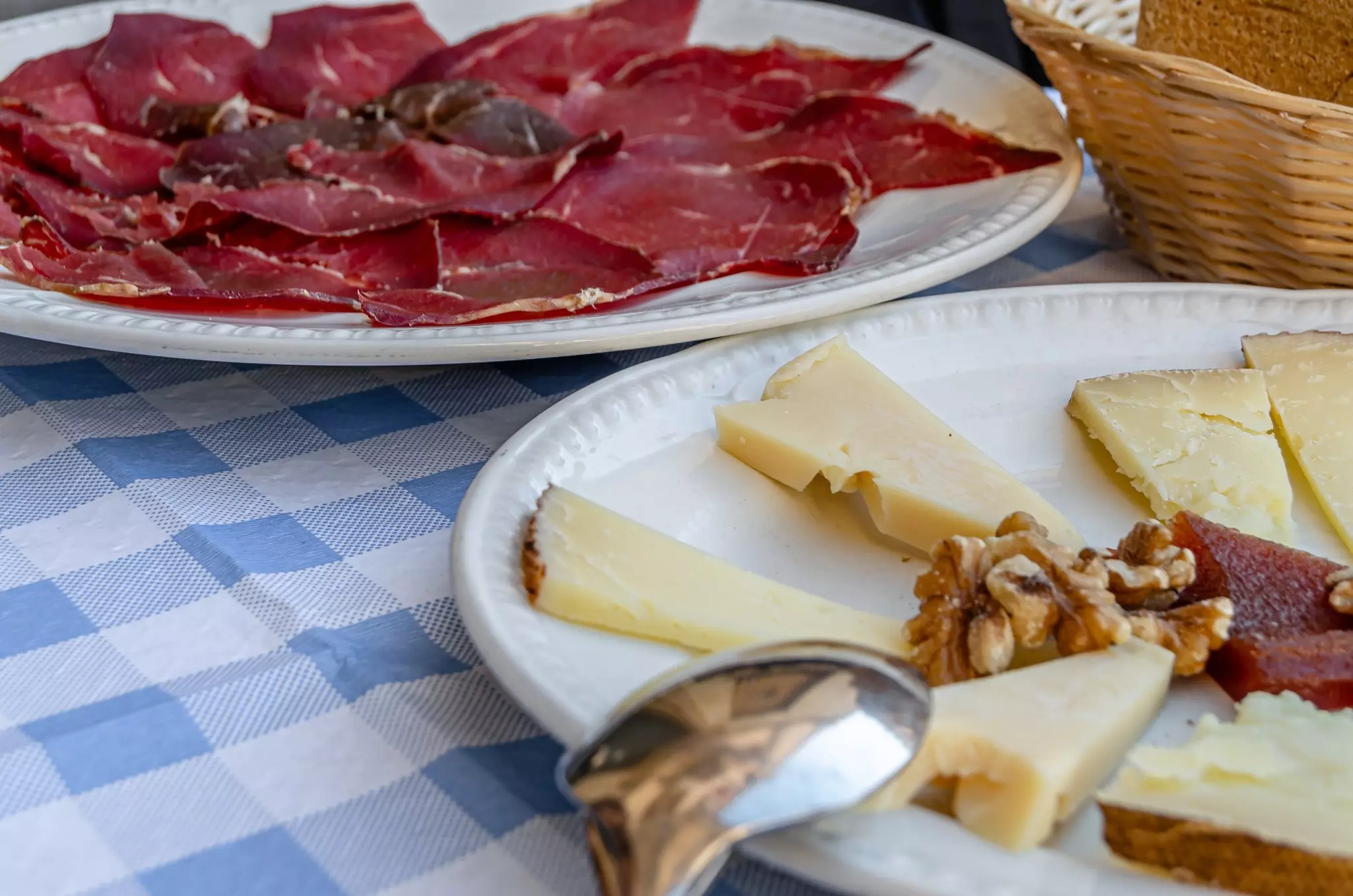 Table with typical Spanish tapas including cheese and cured meat