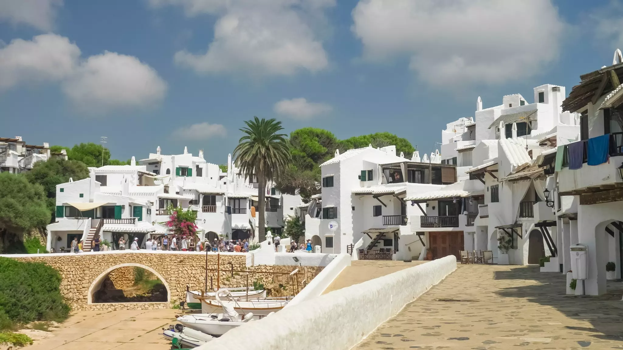 A whitewashed village of low-rise buildings each with steps up to a central balcony.