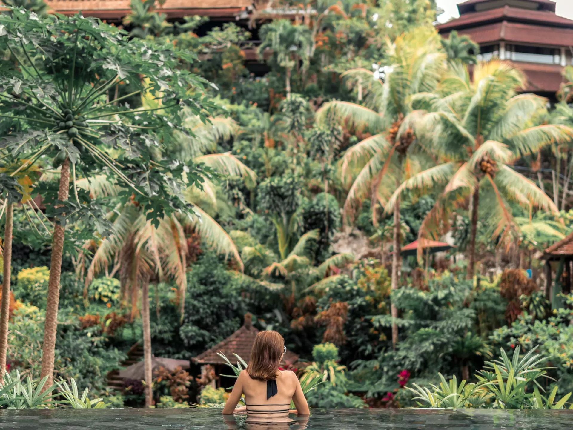 Happy young woman in a tropical infinity pool. Luxury resort on Bali island.  License Type: media  Download Time: 2021-09-30T20:27:44.000Z  User: zachary.laks_lonelyplanet  Is Editorial: No  purchase_order: