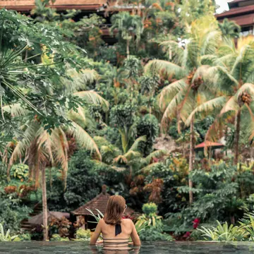 Happy young woman in a tropical infinity pool. Luxury resort on Bali island.  License Type: media  Download Time: 2021-09-30T20:27:44.000Z  User: zachary.laks_lonelyplanet  Is Editorial: No  purchase_order: