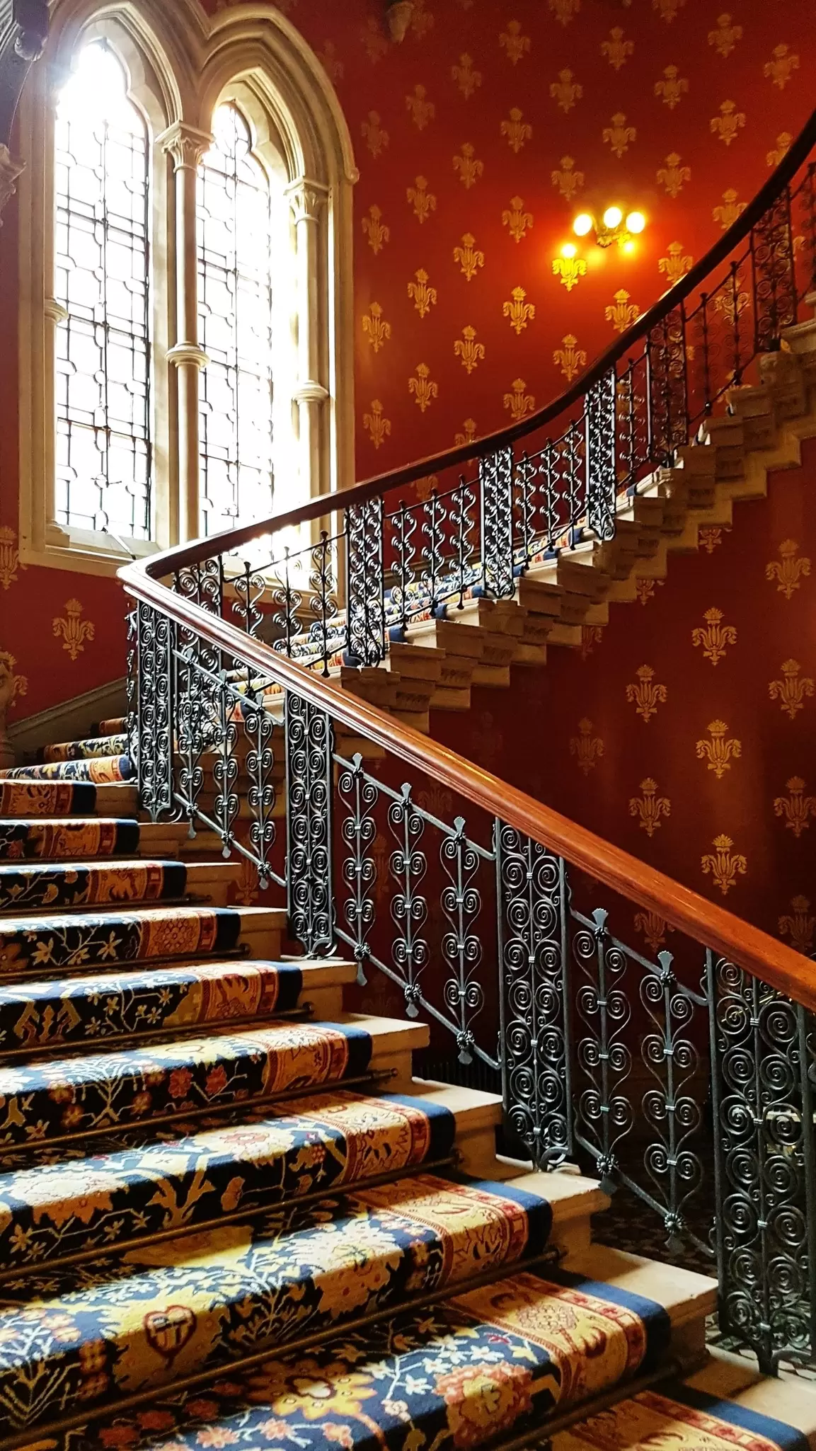 The richly lit and decorated grand staircase of St. Pancras Renaissance Hotel in London, UK.