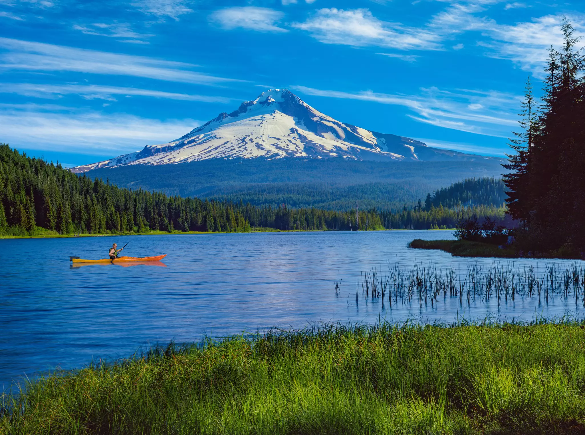 A kayaker on Trillium Lake with the reflection of Mt. Hood