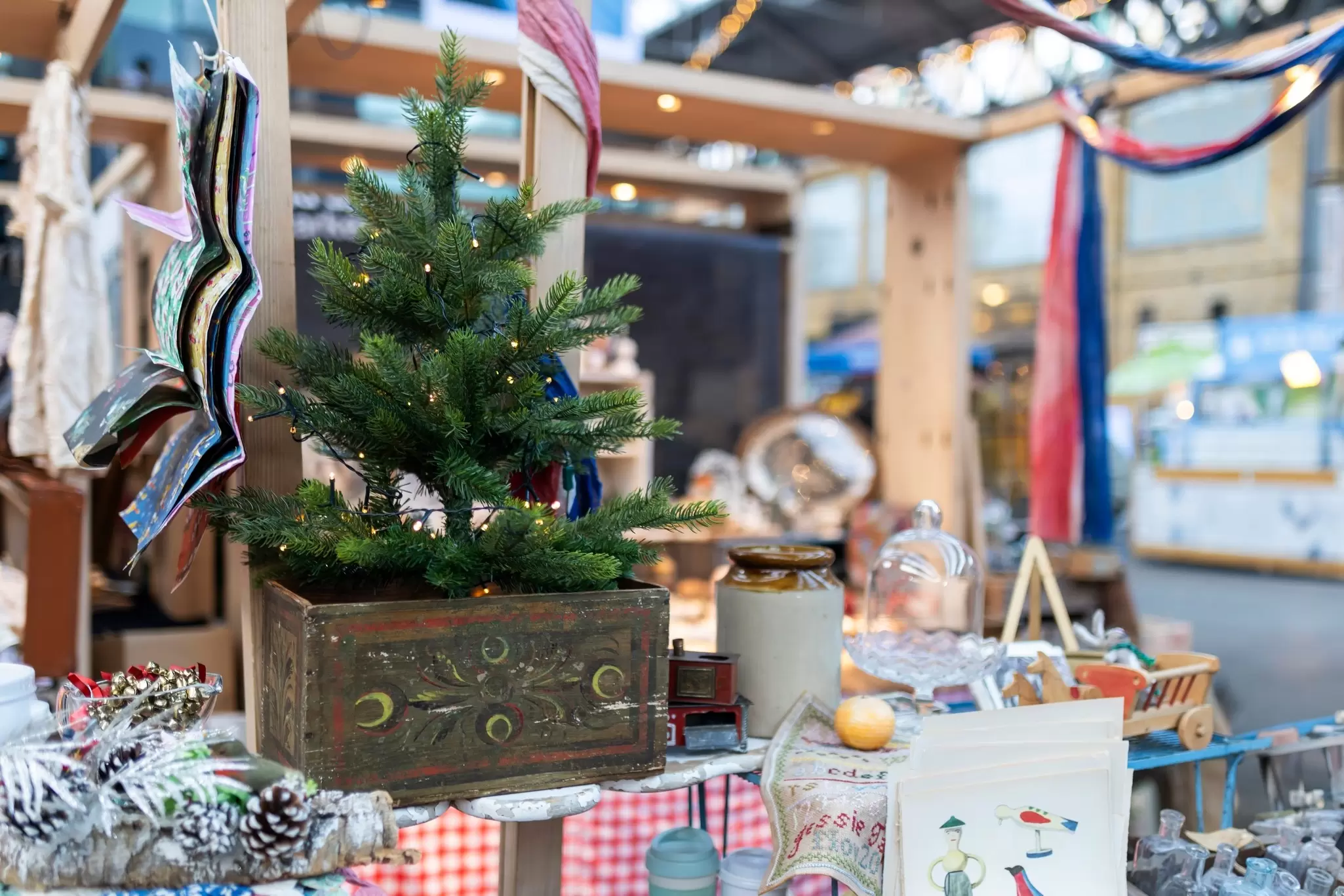 A display with New Year and Christmas items. A Christmas tree with a garland on a vintage box.