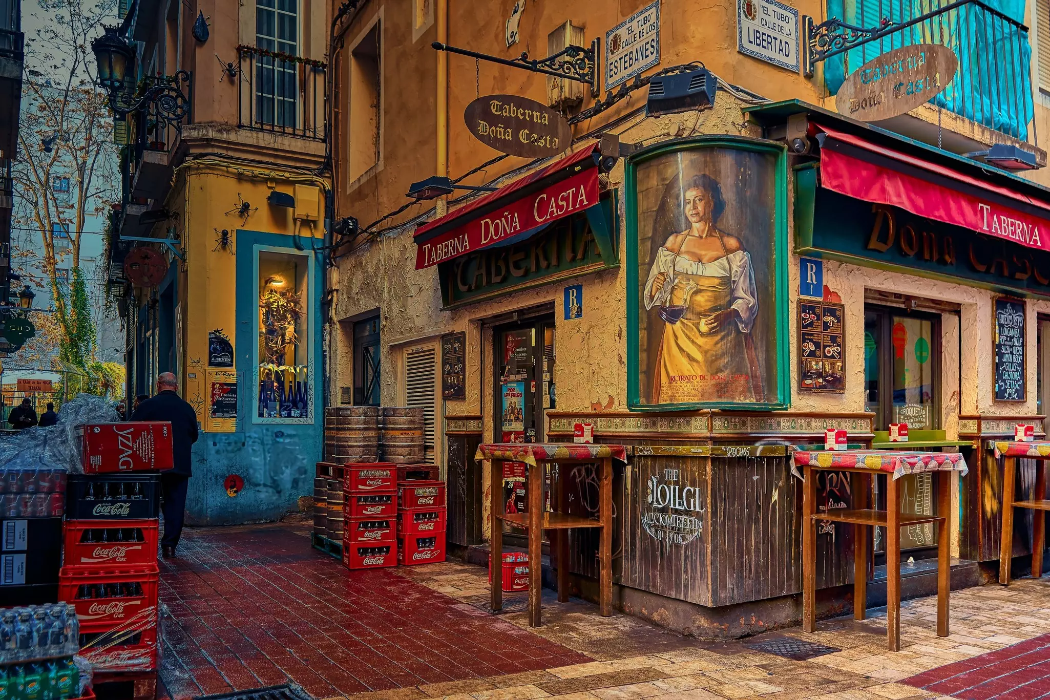 A narrow alley in El Tubo, Zaragoza, Spain, known for its tapas bars and nightlife. View of the historic pedestrian street with colorful facades and local charm.