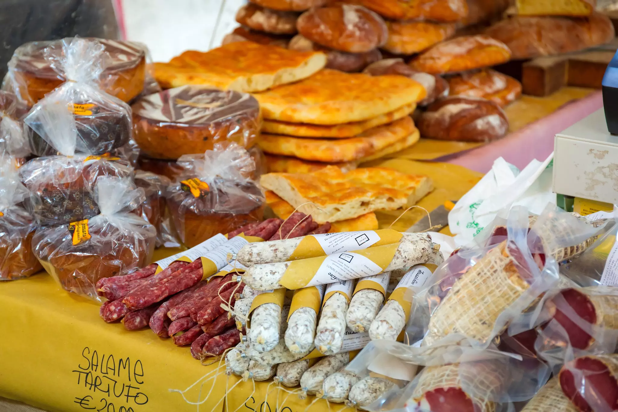 Bread and salami on sale on a table in a street food market.