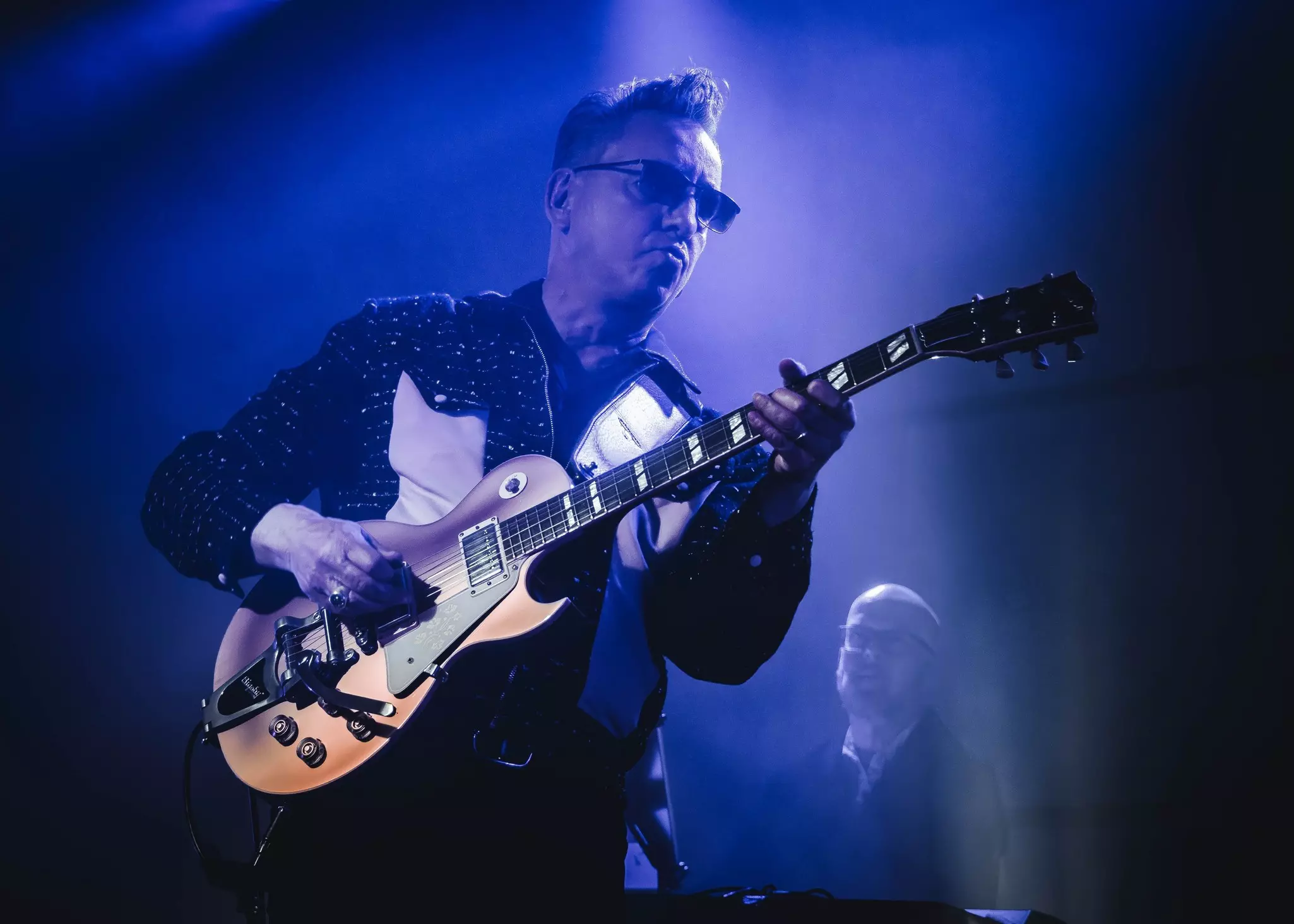 A musician playing live on a stage in Glasgow, Scotland.