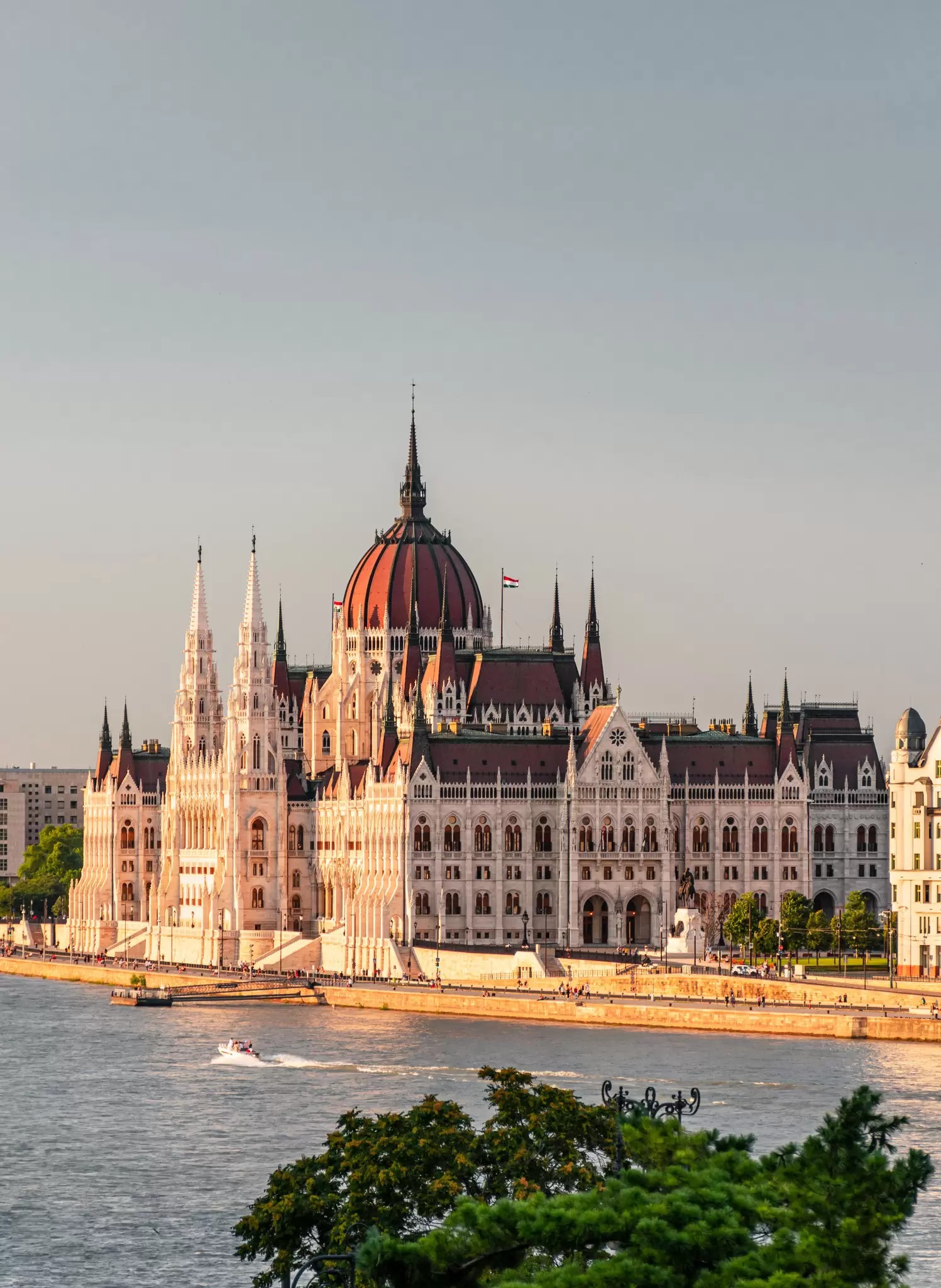 View of the Hungarian Parliament buildings at dusk by the Danube River in Budapest, Hungary.