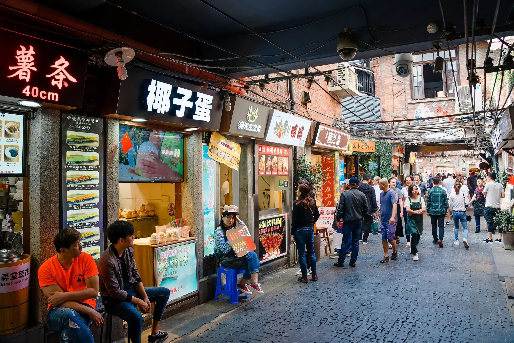 Visitors walk past shopfronts in Tianzifang, a neighborhood of Shanghai, China.