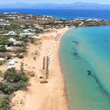 Aerial view of the long golden sand beach and turquoise sea at Hrysi Akti (Golden Beach) on Paros