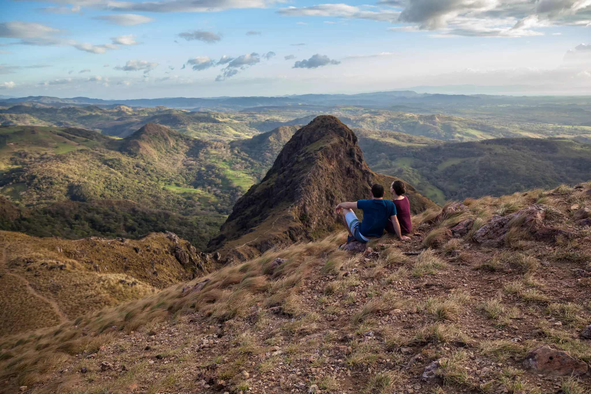 A couple enjoying the spectacular views of Guanacaste from the top of Cerro Pelado at sunset.