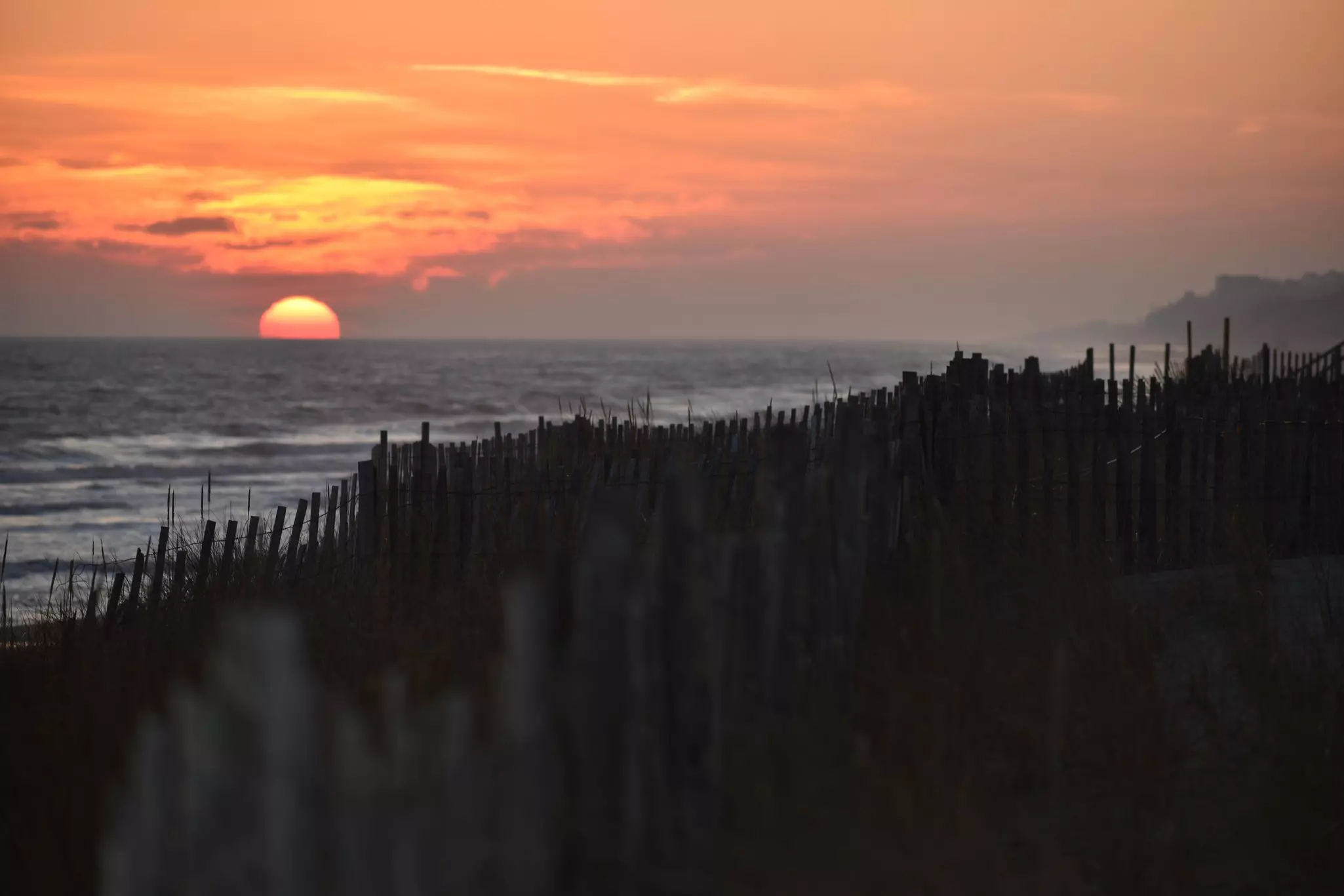 Sunset over dunes by the sea.