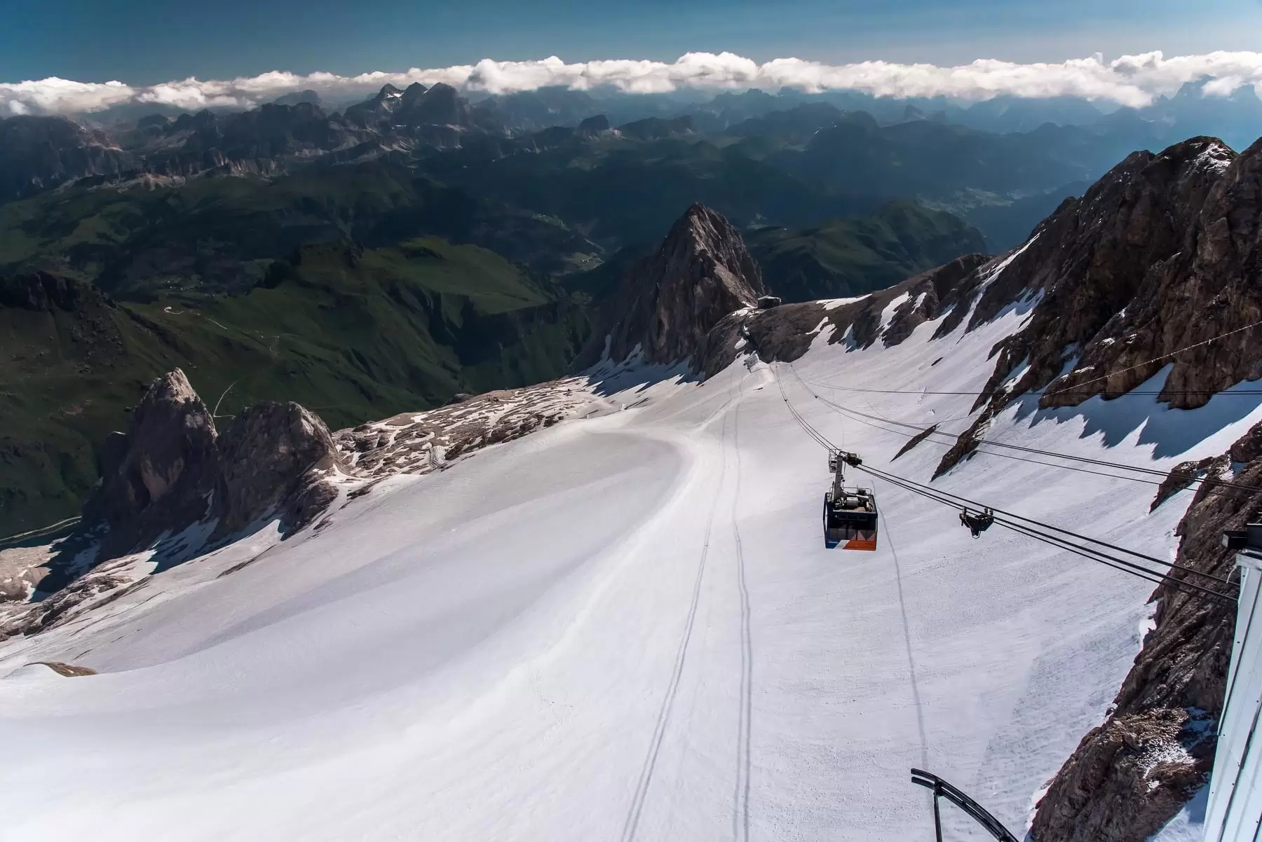 A gondola climbs into the Dolomites at Marmolada, Veneto, Italy.