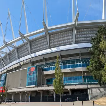 The exterior of a large stadium with an icon of a roaring lion next to the letters "BC"