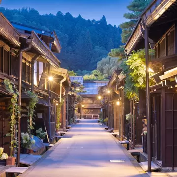 Empty lane of dark wooden Edo-era houses in Takayama old town at blue hour, with lit street lamps and potted hydrangeas