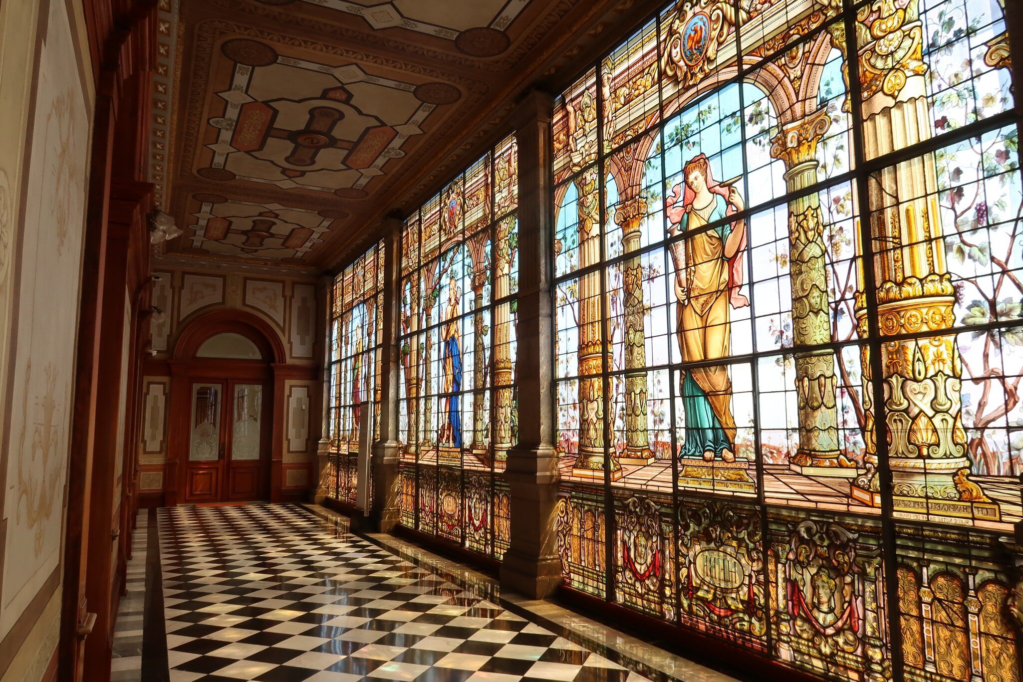 View down a hallway with stained glass windows at the Castillo de Chapultepec in Mexico City.