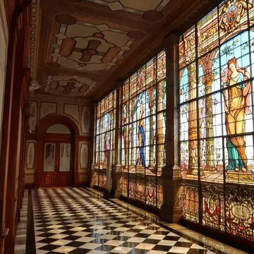 View down a hallway with stained glass windows at the Castillo de Chapultepec in Mexico City.
