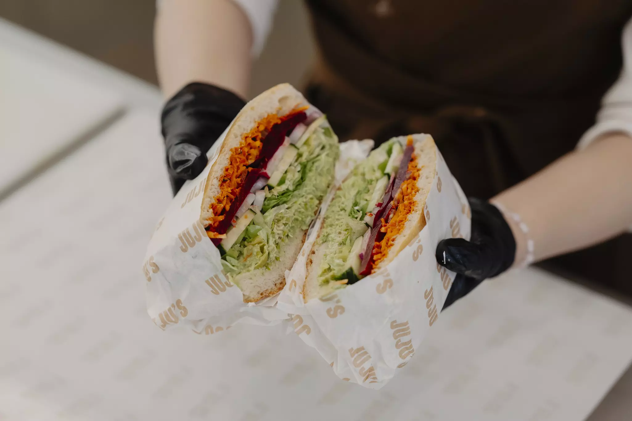 A cross-section of a large foccacia packed with lettuce, beetroot, cucumber and shredded carrot.