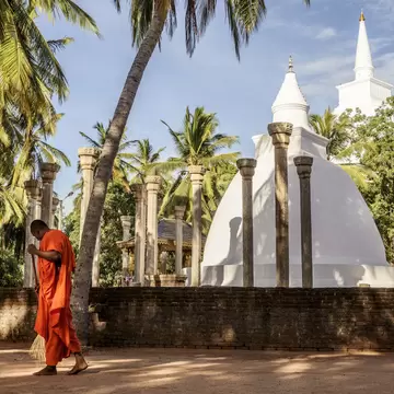 A monk sweeps the ground at a temple in Mihintale, Sri Lanka.