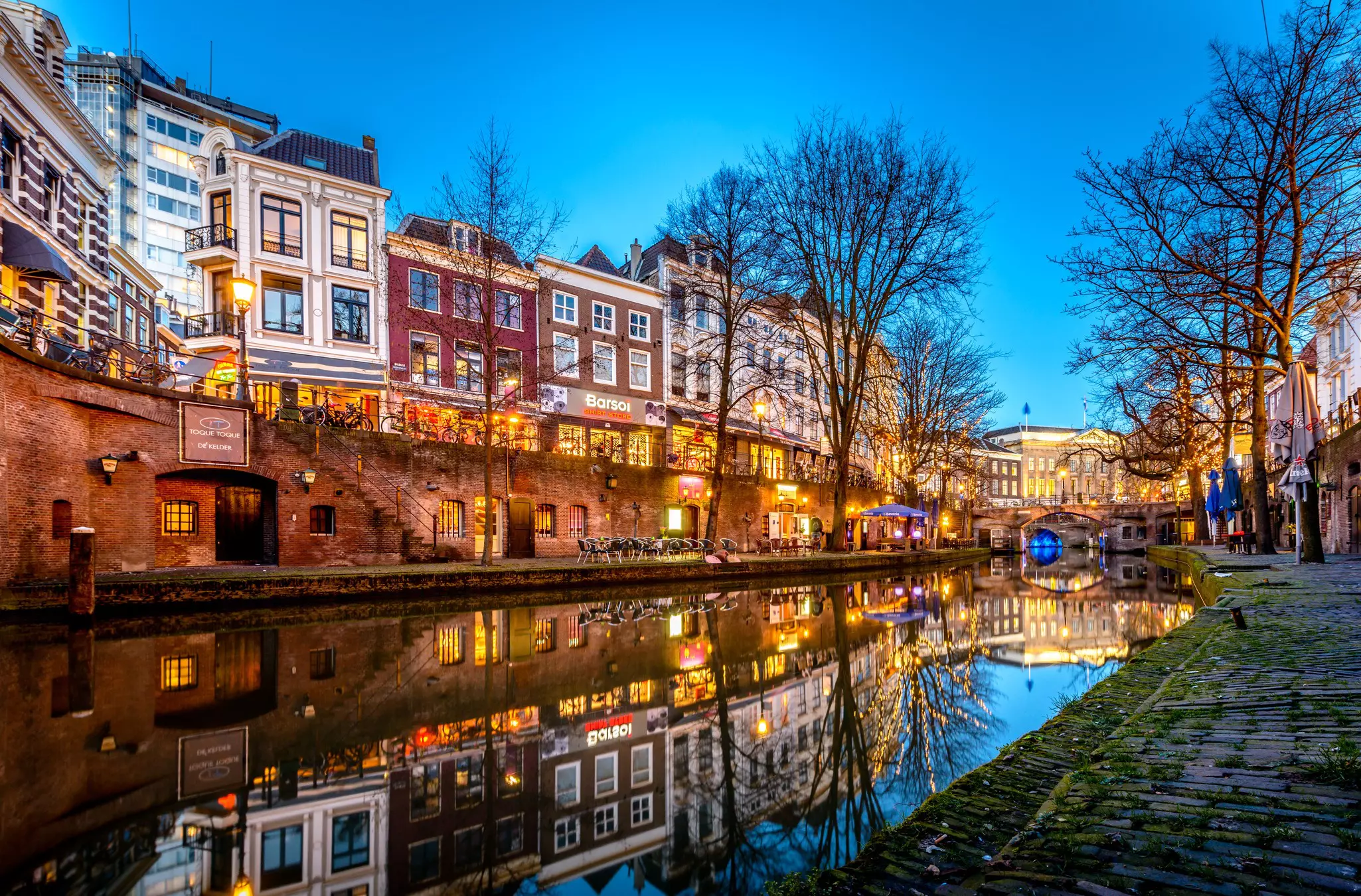 The canalside in Utrecht is lit up at dusk