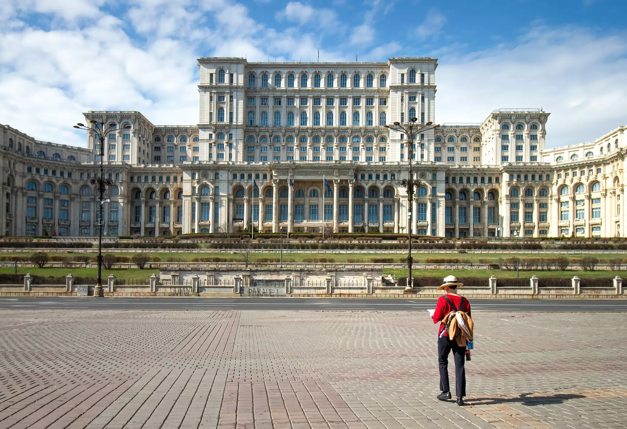 View of a tourist in front of the Palace of Parliament in Bucharest, Romania.