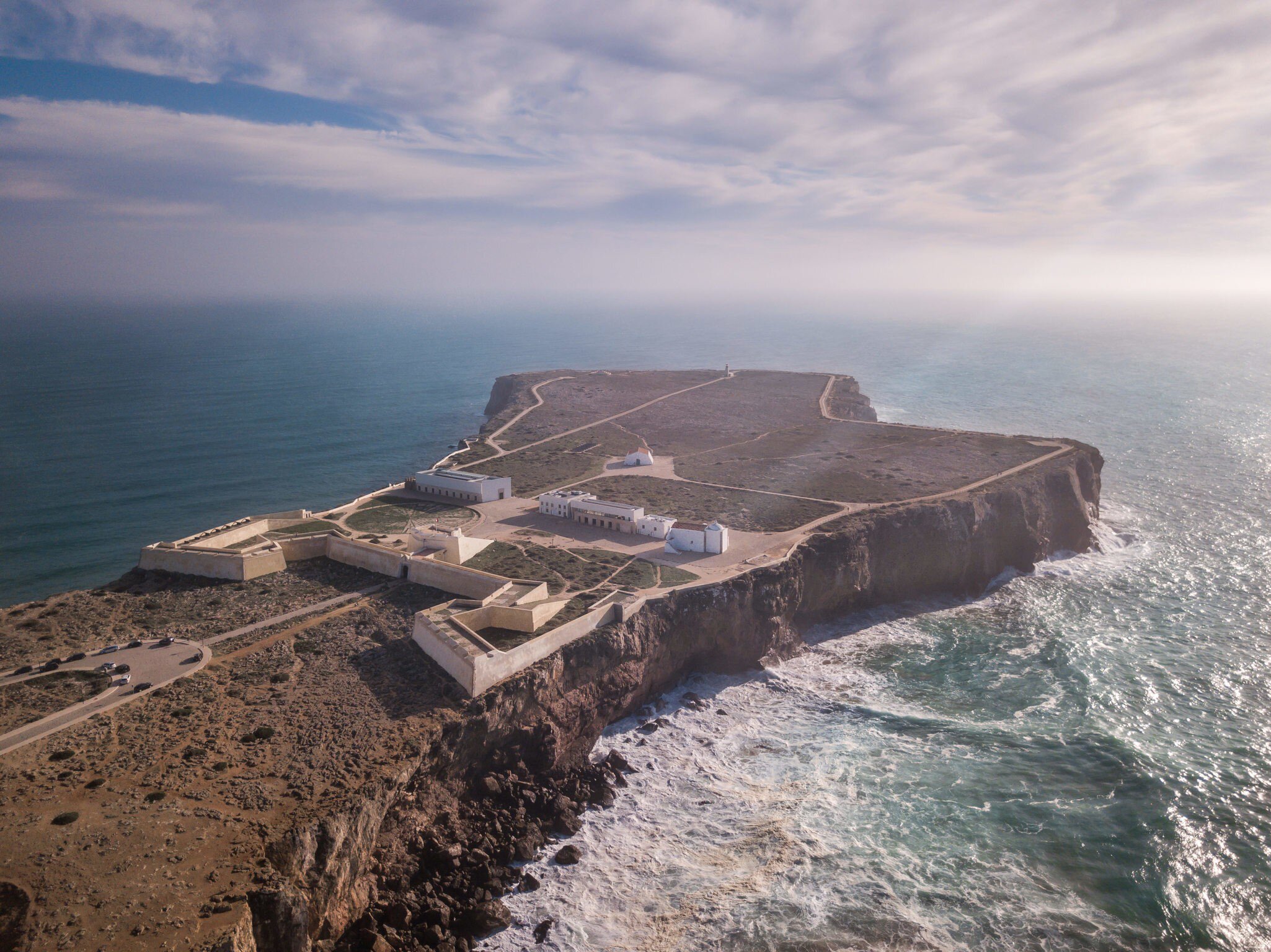 Aerial view of Fortaleza de Sagres, surrounded by the ocean on a sunny day in Portugal.
