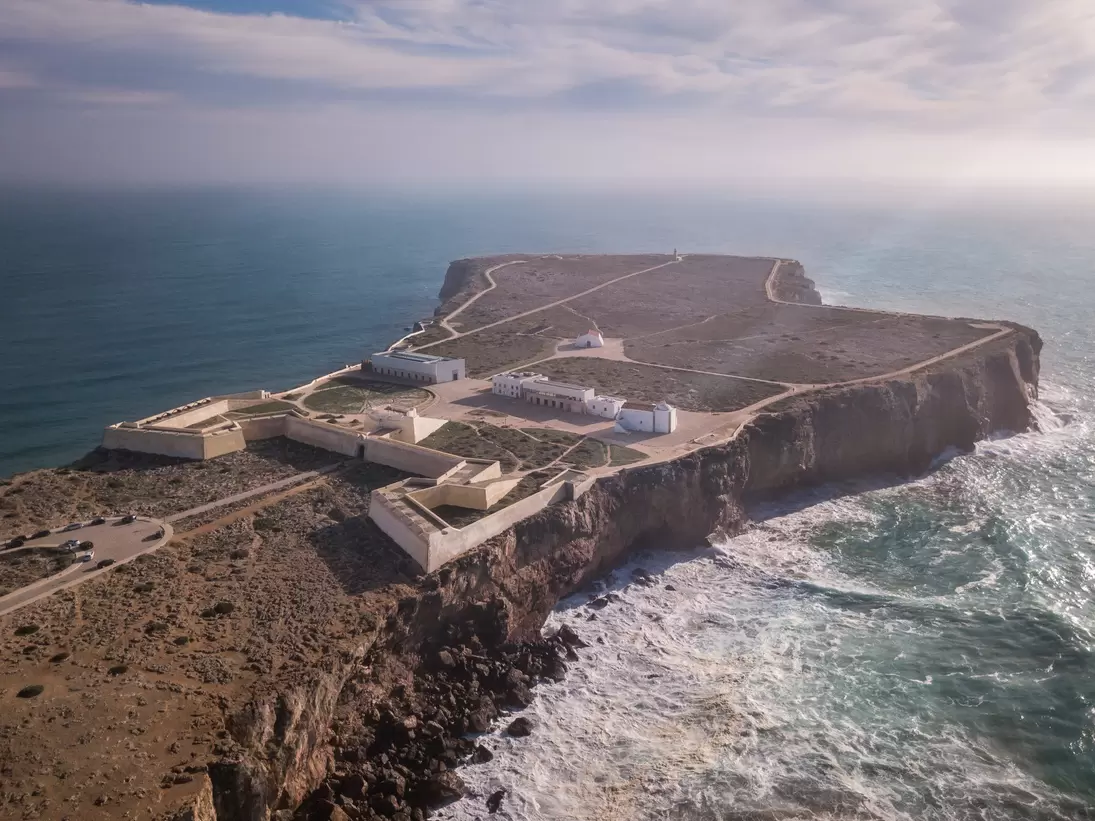 Aerial view of Fortaleza de Sagres, surrounded by the ocean on a sunny day in Portugal.