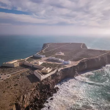 Aerial view of Fortaleza de Sagres, surrounded by the ocean on a sunny day in Portugal.