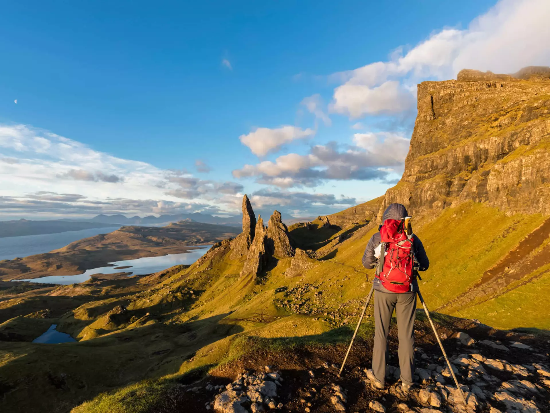 A hiker taking pictures near The Storr mountain peak on the Isle of Skye.