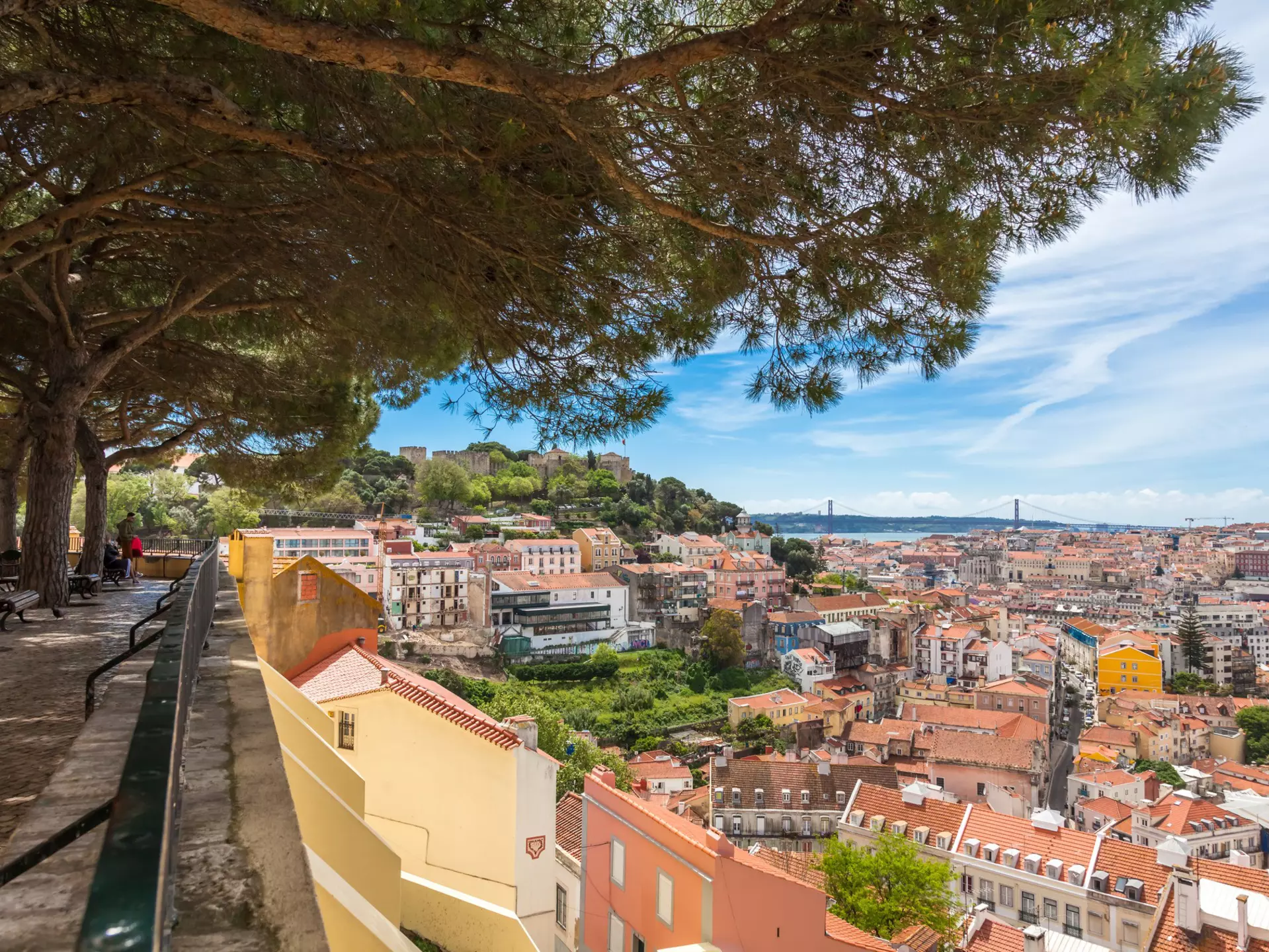 A viewpoint over a city with many hills and red-roofed buildings.