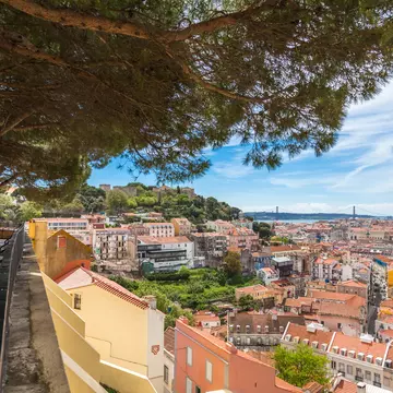 A viewpoint over a city with many hills and red-roofed buildings.