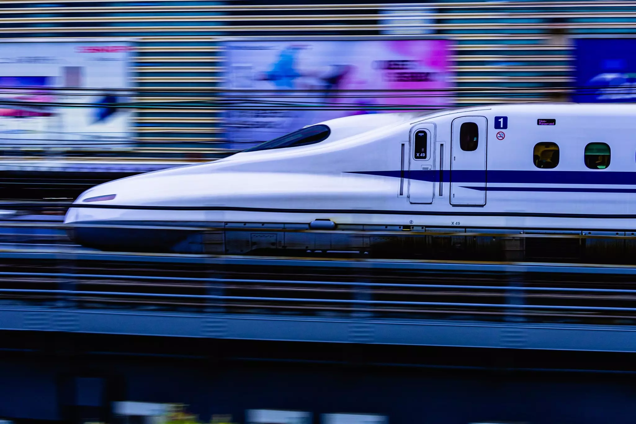 A white high-speed train going through a rail station