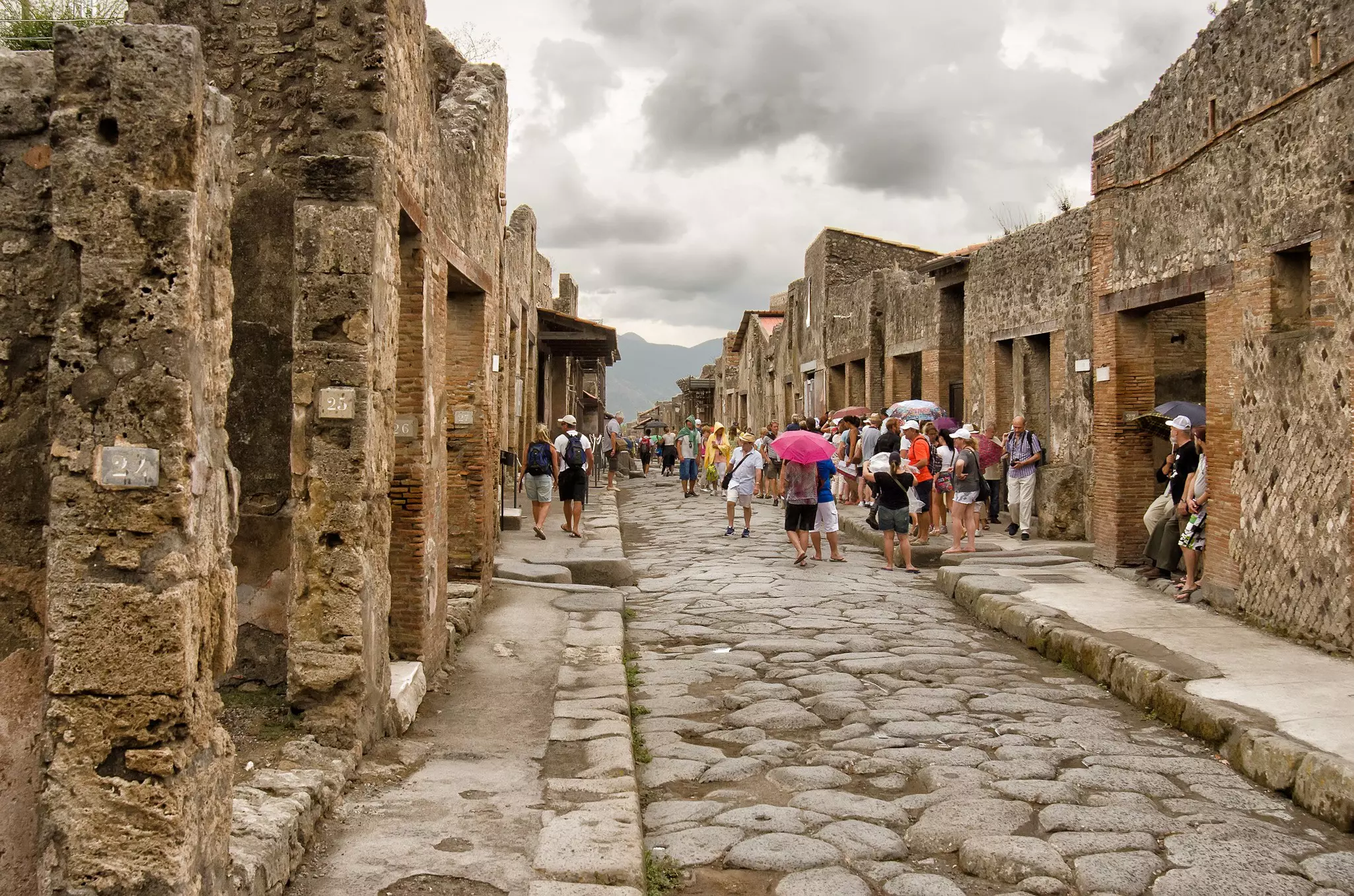 Tourists visit a ruined street in Pompeii, Campania, Italy.