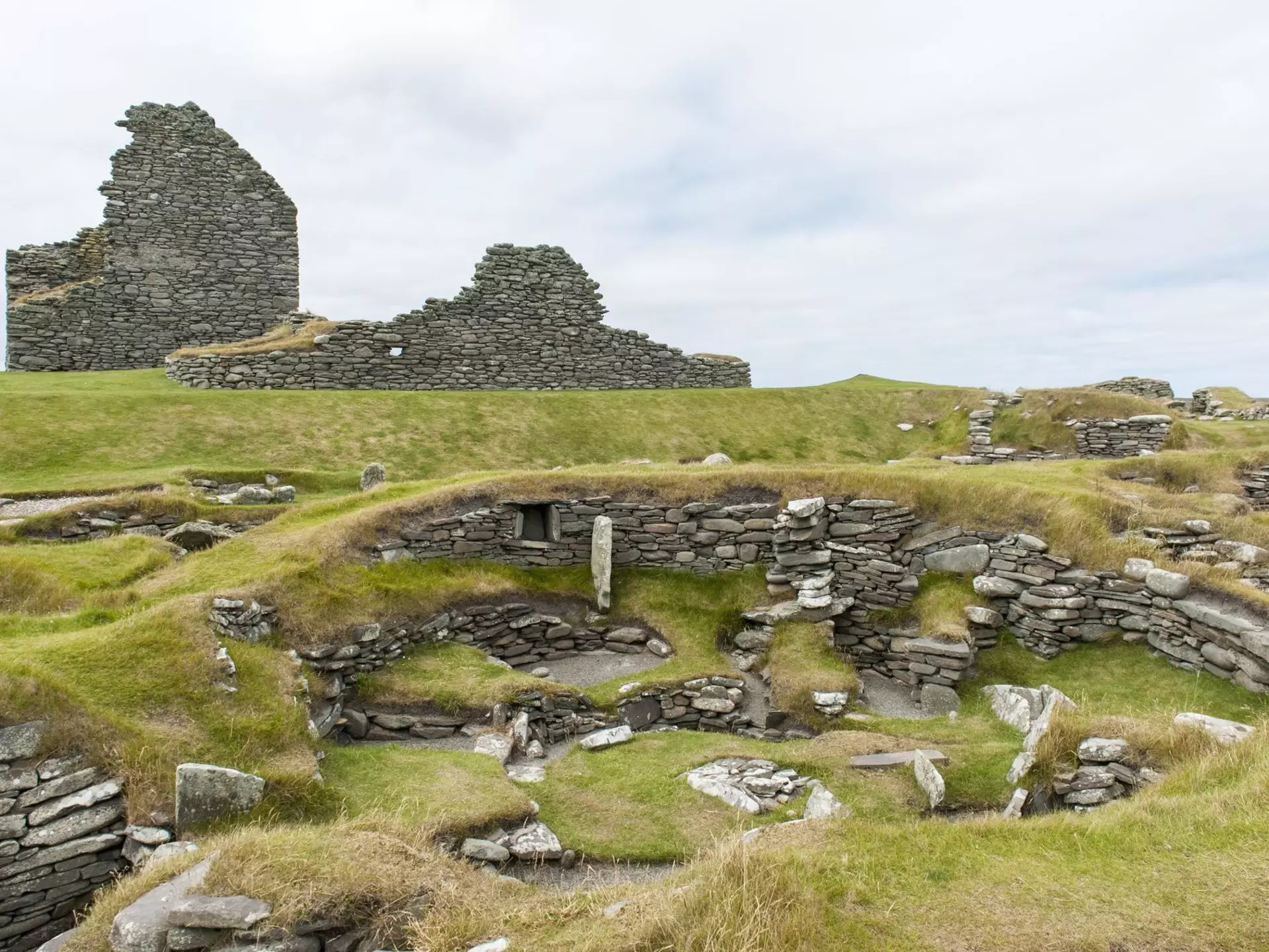 Archaeology, prehistoric archaeological site, Bronze Age building in front, half-destroyed broch in back, Jarlshof, Mainland, Shetland Islands, Scotland, United Kingdom