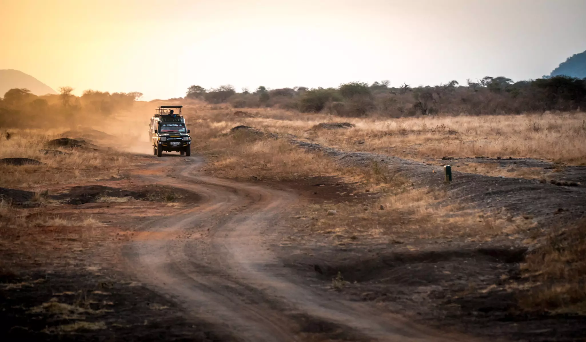 A 4WD crossing the savannah in Tsavo East National Park, Kenya.