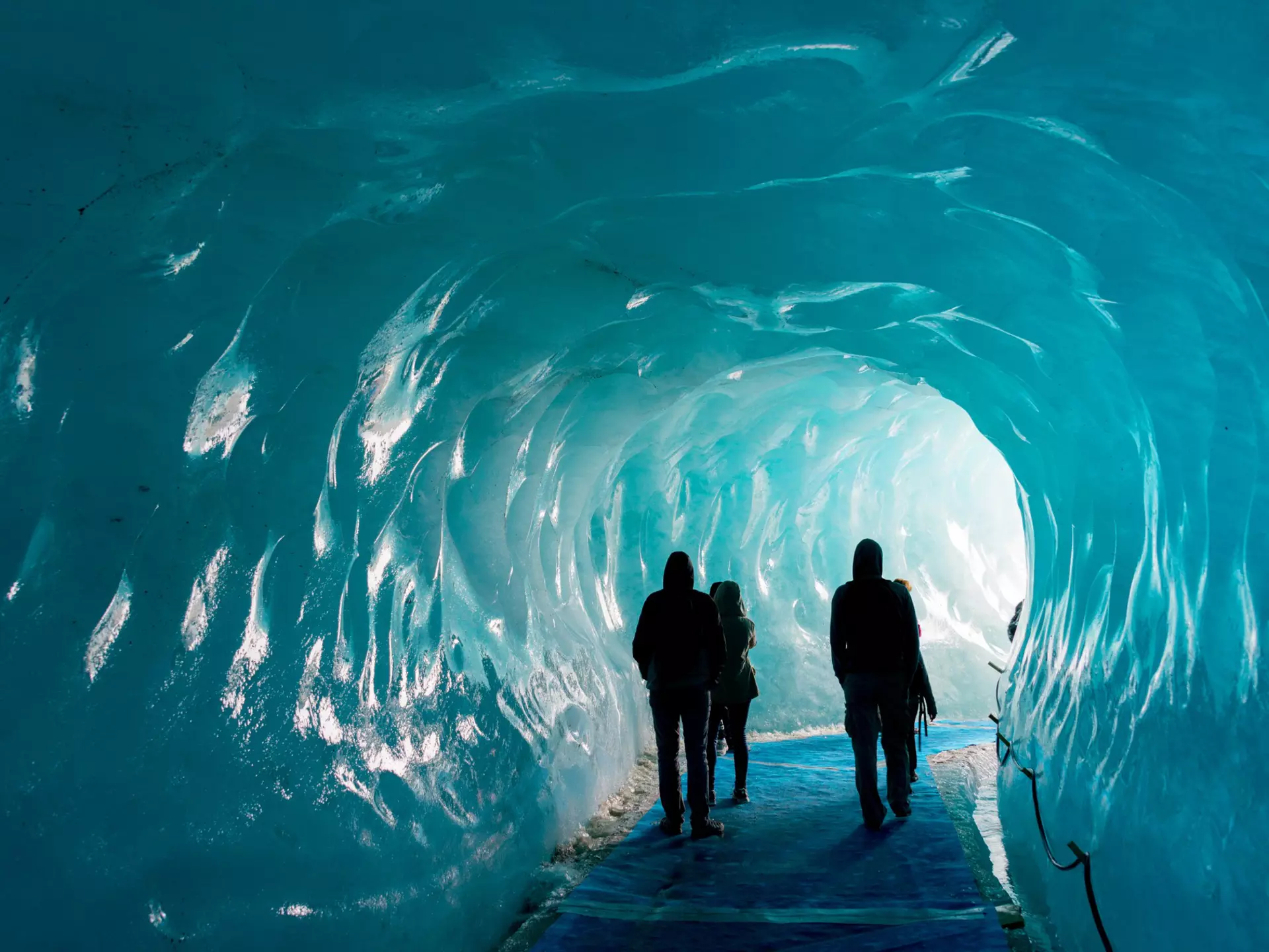 Silhouettes of people visiting thee ice cave of the Mer de Glace glacier,  in Chamonix Mont Blanc Massif, The Alps, France, License Type: media, Download Time: 2025-08-20T22:48:11.000Z, User: krista950237, Editorial: false, purchase_order: 56500 - T&R or Kids, job: Global Publishing WIP, client: A Kid's Guide to France, other: Krista Rossow
