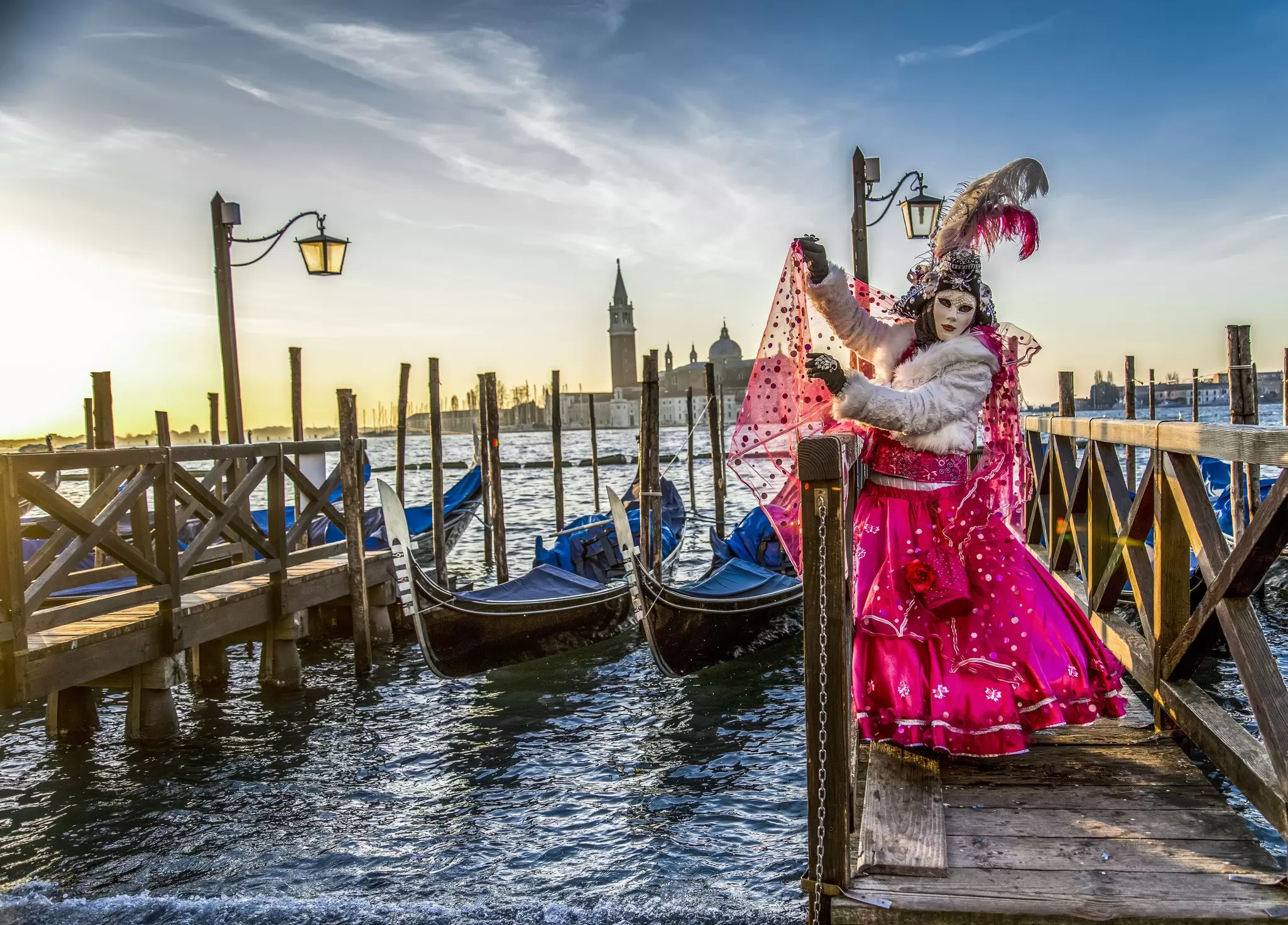 Venice naturally provides a dramatic backdrop for a festival goer in full costume. Vigen M / Shutterstock