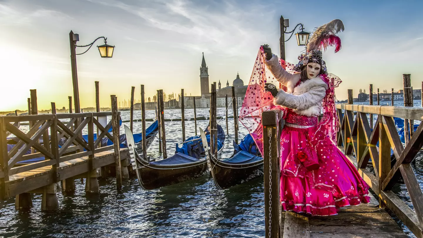 Venice naturally provides a dramatic backdrop for a festival goer in full costume. Vigen M / Shutterstock
