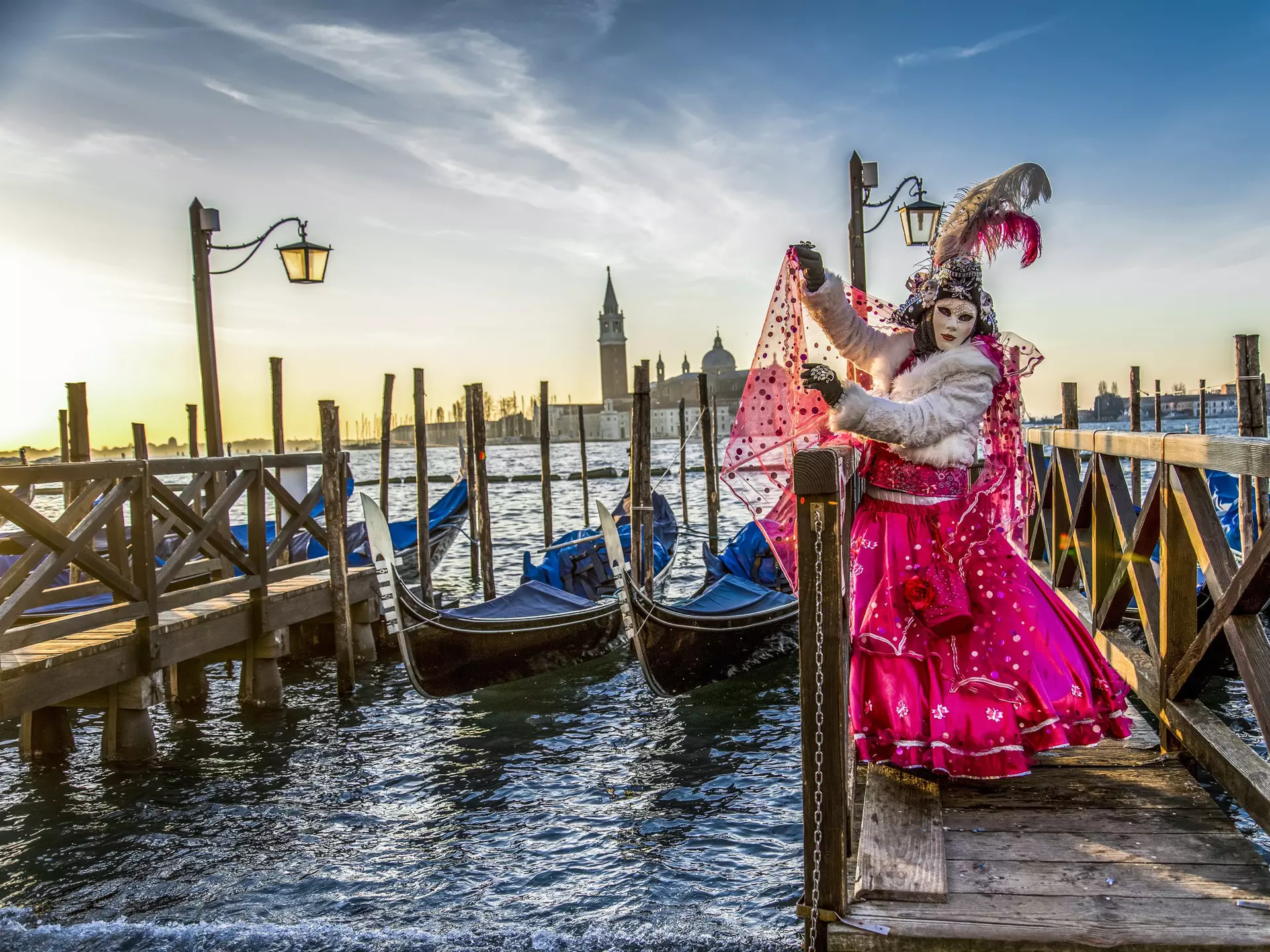 Venice naturally provides a dramatic backdrop for a festival goer in full costume. Vigen M / Shutterstock