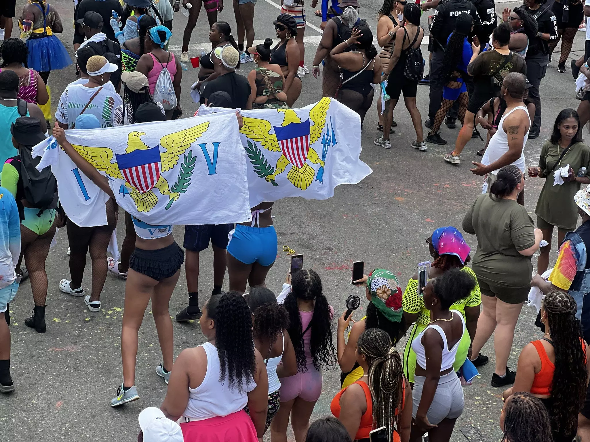 A pair of women drape a pair of USVI flags over their backs during J'Ouvert in St Thomas.
