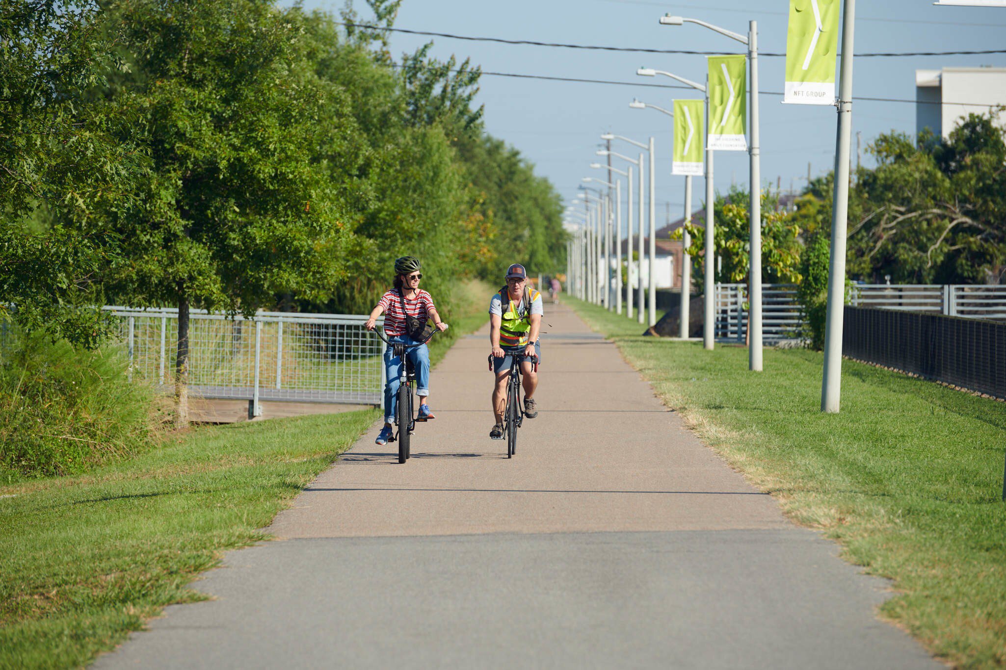 People cycle on a sunny day along the Lafitte Greenway in New Orleans, Louisiana.