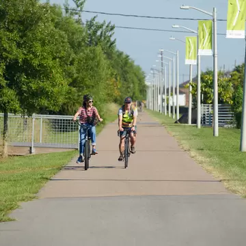 People cycle on a sunny day along the Lafitte Greenway in New Orleans, Louisiana.