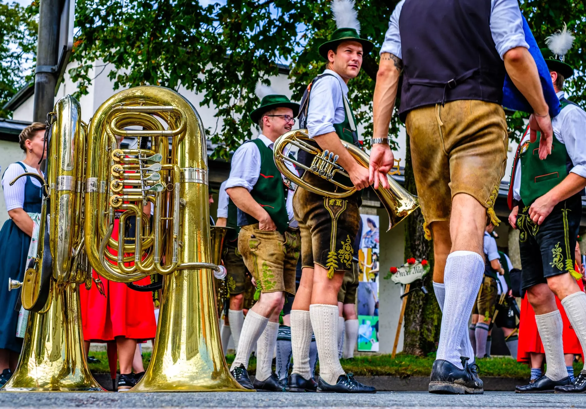 Participants wearing lederhosen and other traditional dress march in a parade for Herbstfest Rosenheim in Bavaria, Germany.