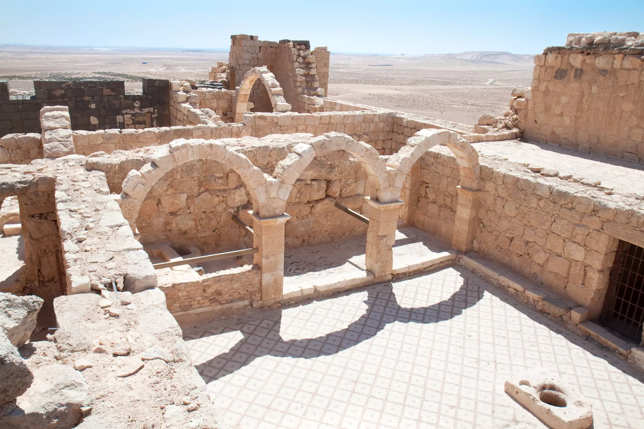 The ruined archways within a castle in the desert.