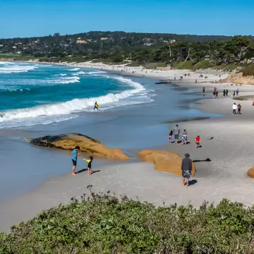 Families and dog walkers enjoy the sandy shores of Carmel Beach, along the Monterey Bay of the central California coast.  
