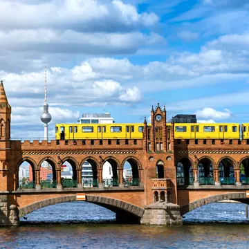 A yellow train passing over Oberbaum Bridge in Berlin, Germany. 