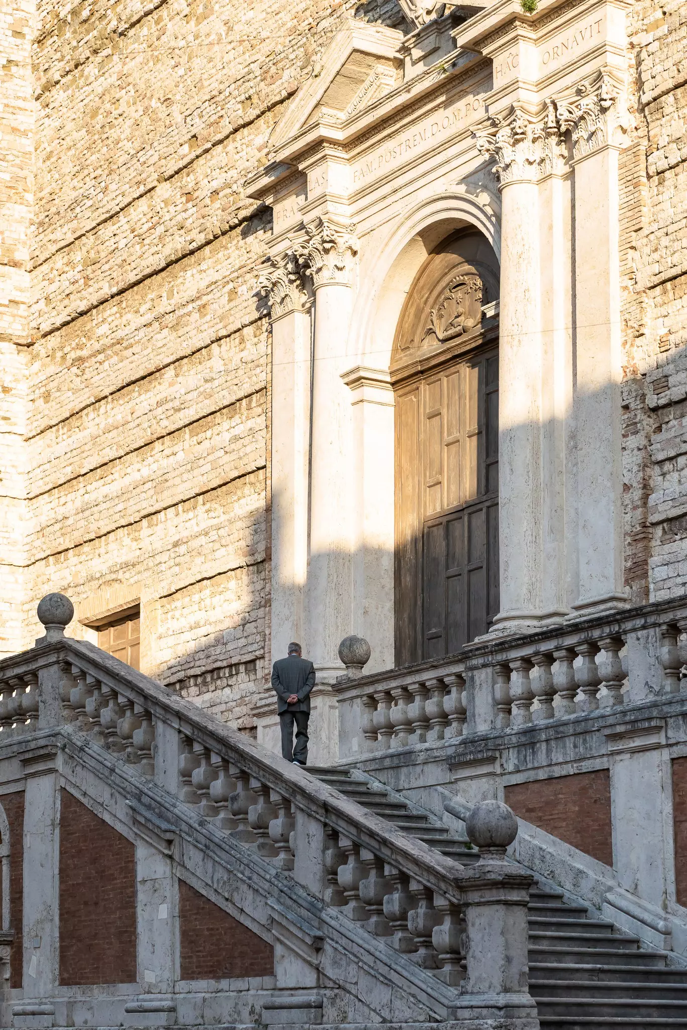 Emma and her friend Helen stand in front of a green lake with trees in the background and a statue in front of it.