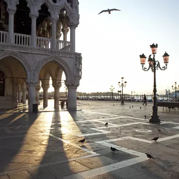 Light streaming through archways of the Palazzo Ducale on Piazza San Marco in Venice, Italy.