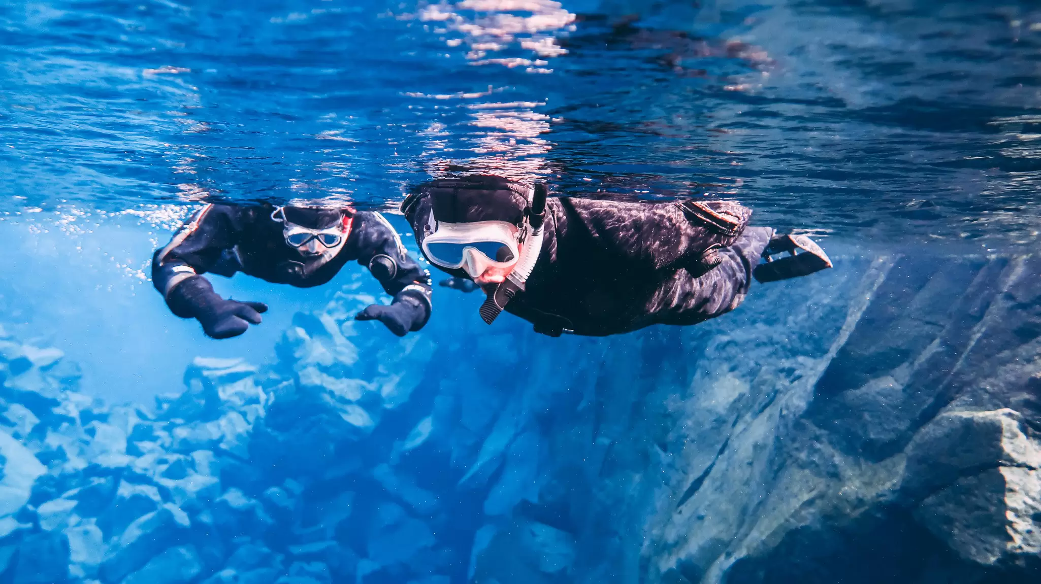 People snorkeling in the famous Silfra in Þingvellir National Park, Iceland.