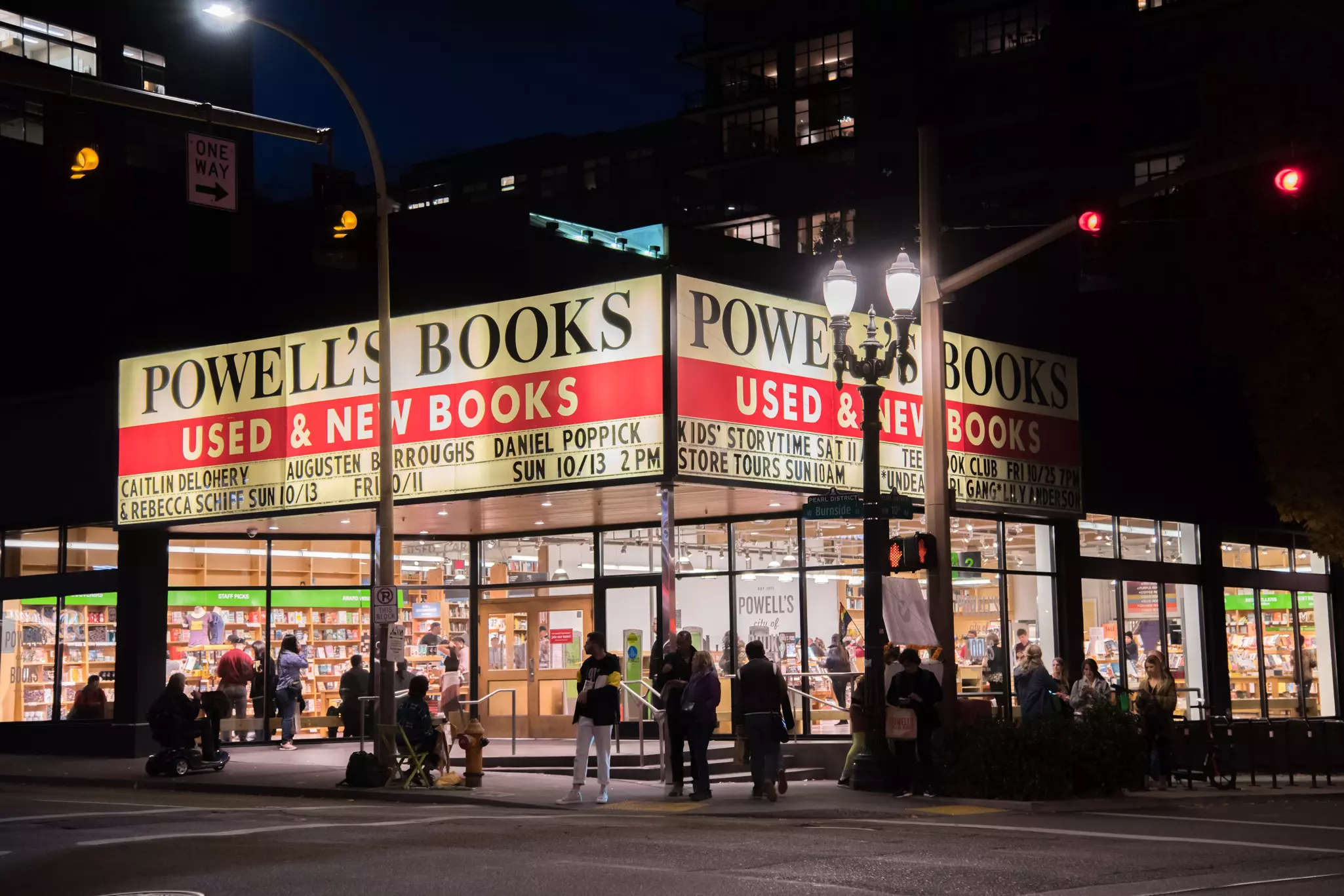 A bookstore with a large marquee in the downtown of a city is pictured at night.